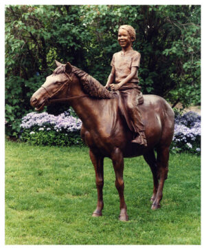 Realistic bronze sculpture life-size of a beaming young girl on her pony
