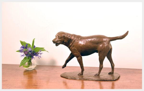 Table-size bronze sculpture of a happy Labrador Retriever right foot extended